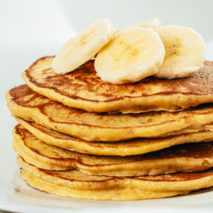 PCOS Breakfast Idea-Large stack of Paleo Banana Pancakes garnished with sliced bananas